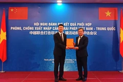 El teniente general Pham Dang Khoa entrega un recuerdo a un representante de la delegación china. Foto: cand.com.vn