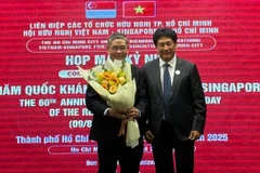 El presidente de la VSFA entrega flores al cónsul general de Singapur en la ciudad de Ho Chi Minh, Pang Te Cheng, en la reunión (Fuente: sggp.com)