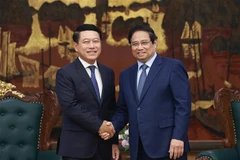 El primer ministro vietnamita, Pham Minh Chinh (derecha) recibe al vicepremier laosiano Saleumxay Kommasith (Fuente: VNA)