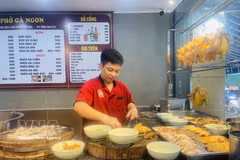 Un chef prepara pho de pollo para los clientes en un restaurante de pho en la zona urbana de Linh Dam, Hanoi. Foto: VNA