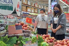Los consumidores eligen manzanas estadounidenses en un supermercado de la ciudad de Ho Chi Minh. (Foto: nld.com.vn)