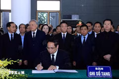 El primer ministro Pham Minh Chinh escribiendo en el libro de condolencias (Fuente: VNA)