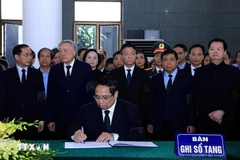 El primer ministro Pham Minh Chinh escribiendo en el libro de condolencias (Fuente: VNA)