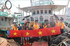 El Comando de la Región 3 de la Guardia Costera organizó un programa para difundir las leyes sobre la lucha contra la pesca IUUy entregó banderas nacionales a los pescadores. Foto: VNA