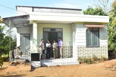 Y Dani Hd Ok, residente de la aldea de La, provincia de Dak Lak, y su esposa frente a su casa recién construida. (Foto: VNA)
