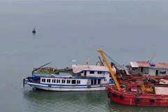 El barco turístico Vinh Xanh 58 es remolcado a tierra la mañana del 20 de julio. (Foto: VNA)