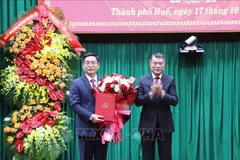 Le Minh Hung, miembro del Buró Político, secretario del Comité Central del PCV y jefe de su Comisión de Organización felicaita a Nguyen Dinh Trung (Fuente: VNA)