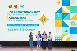 Nguyen Hoang Hiep, Viceministro de Agricultura y Medio Ambiente, y Pauline Tamesis, Coordinadora Residente de la ONU en Vietnam, entregaron flores en reconocimiento a la OMS y la OIM como miembros de la alianza. Foto: VNA