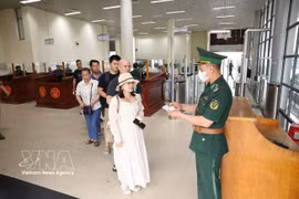 Guardias en el puesto fronterizo internacional de Mong Cai en la provincia de Quang Ninh tramitan procedimientos de salida de pasajeros. (Foto: VNA)