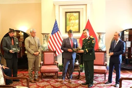 Representante de la VFW (izquierda) entrega recuerdos de la guerra a la parte vietnamita. (Foto: VNA)