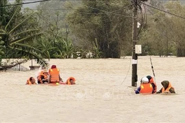 Las autoridades se adentrann en las aguas para rescatar a pobladores. Foto: VNA