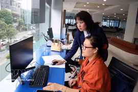 Funcionarios del Centro de Servicios Administrativos Públicos de la Ciudad de Hanoi gestionan trámites administrativos para los ciudadanos. (Foto: VNA)