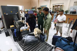 Los agentes de aduanas inspeccionan el equipaje de los pasajeros que ingresan al país a través del puesto fronterizo internacional de Nam Can, en la provincia de Nghe An. Foto: VNA