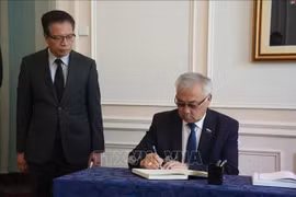 Bair Zhamsuyev, vicepresidente del Comité de Asuntos Exteriores del Consejo de la Federación de la Asamblea Federal de Rusia, escribe en el libro de condolencias durante la ceremonia celebrada por la Embajada de Vietnam en Rusia. (Foto: VNA)