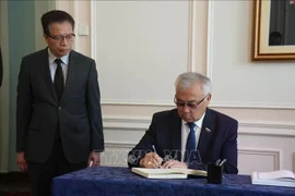 Bair Zhamsuyev, vicepresidente del Comité de Asuntos Exteriores del Consejo de la Federación de la Asamblea Federal de Rusia, escribe en el libro de condolencias durante la ceremonia celebrada por la Embajada de Vietnam en Rusia. (Foto: VNA)