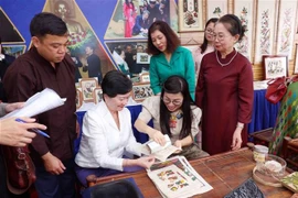 La esposa del primer ministro Pham Minh Chinh, Le Thi Bich Tran, y los delegados realizan pinturas folclóricas de Dong Ho (Foto: VNA)