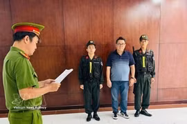 El sospechoso, Nguyen Thanh Hiep, escucha mientras la agencia de investigación le entrega las decisiones procesales. (Foto: VNA)