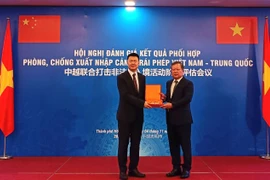 El teniente general Pham Dang Khoa entrega un recuerdo a un representante de la delegación china. Foto: cand.com.vn