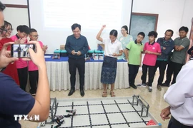 Profesores y alumnos experimentan con la robótica. (Foto: VNA)