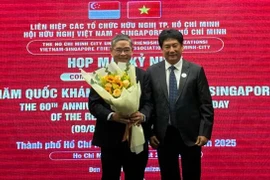 El presidente de la VSFA entrega flores al cónsul general de Singapur en la ciudad de Ho Chi Minh, Pang Te Cheng, en la reunión (Fuente: sggp.com)