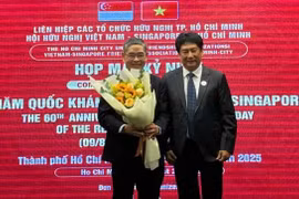 El presidente de la VSFA entrega flores al cónsul general de Singapur en la ciudad de Ho Chi Minh, Pang Te Cheng, en la reunión (Fuente: sggp.com)