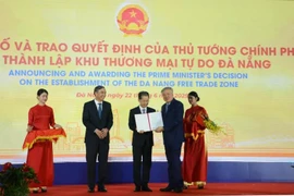 El viceprimer ministro Nguyen Hoa Binh (segundo desde derecha) presenta la decisión del Primer Ministro de establecer la Zona de Libre Comercio de Da Nang el 22 de junio. (Foto: VNA)