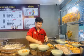 Un chef prepara pho de pollo para los clientes en un restaurante de pho en la zona urbana de Linh Dam, Hanoi. Foto: VNA