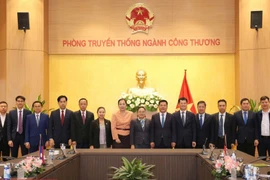 El ministro de Industria y Comercio, Nguyen Hong Dien (sexto desde la derecha), y la embajadora de Laos en Vietnam, Khamphao Ernthavanh (séptima desde la derecha), mantienen una sesión de trabajo. (Foto: tapchicongthuong.vn)