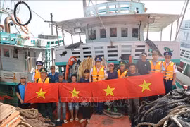 El Comando de la Región 3 de la Guardia Costera organizó un programa para difundir las leyes sobre la lucha contra la pesca IUUy entregó banderas nacionales a los pescadores. Foto: VNA