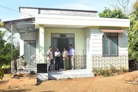 Y Dani Hd Ok, residente de la aldea de La, provincia de Dak Lak, y su esposa frente a su casa recién construida. (Foto: VNA)