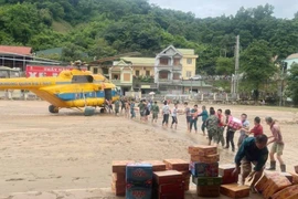 Un helicóptero de la Fuerza Aérea de Defensa Aérea con suministros de socorro aterriza en la comuna de Tuong Duong, provincia de Nghe An. (Foto: VNA)