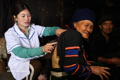Una trabajadora de la salud brinda atención médica domiciliaria a residentes pertenecientes a minorías étnicas. (Foto: VNA)