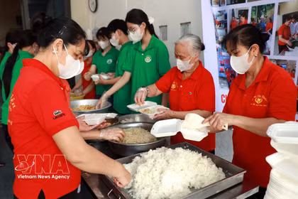Los miembros de la Asociación de Comidas Solidarias y estudiantes de la escuela secundaria Nguyen Khuyen (barrio Nam Dinh) preparan raciones de comida gratuitas para entregar a los pacientes. (Foto: VNA)