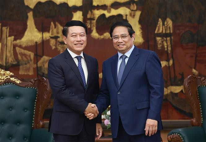 El primer ministro vietnamita, Pham Minh Chinh (derecha) recibe al vicepremier laosiano Saleumxay Kommasith (Fuente: VNA)