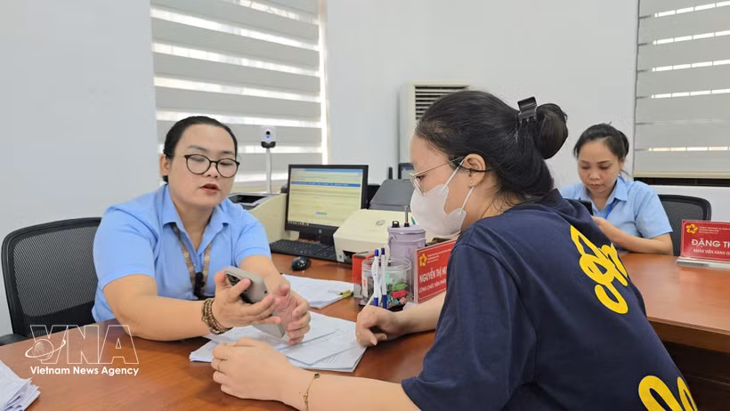 Funcionarios del barrio de Mao Khe orientan a los ciudadanos sobre cómo presentar sus documentos de autenticación en el Portal Nacional de Servicios Públicos. Foto: VNA.