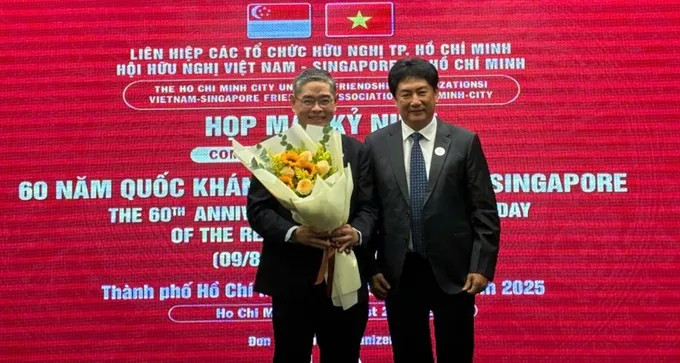 El presidente de la VSFA entrega flores al cónsul general de Singapur en la ciudad de Ho Chi Minh, Pang Te Cheng, en la reunión (Fuente: sggp.com)