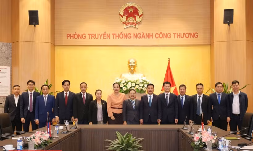 El ministro de Industria y Comercio, Nguyen Hong Dien (sexto desde la derecha), y la embajadora de Laos en Vietnam, Khamphao Ernthavanh (séptima desde la derecha), mantienen una sesión de trabajo. (Foto: tapchicongthuong.vn)