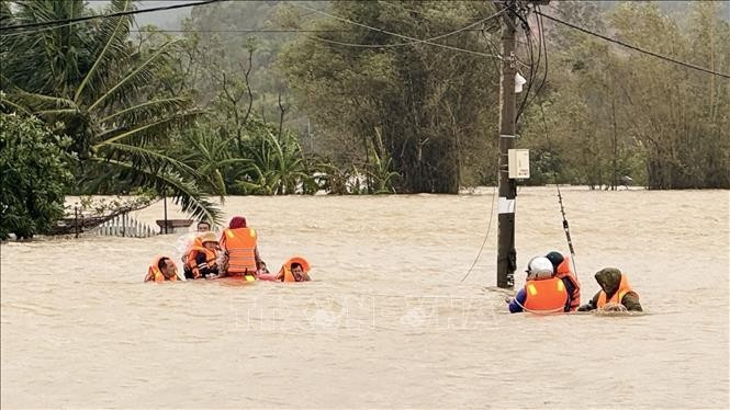 Las autoridades se adentrann en las aguas para rescatar a pobladores. Foto: VNA