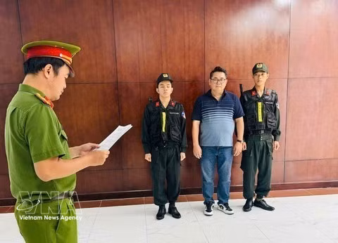 El sospechoso, Nguyen Thanh Hiep, escucha mientras la agencia de investigación le entrega las decisiones procesales. (Foto: VNA)