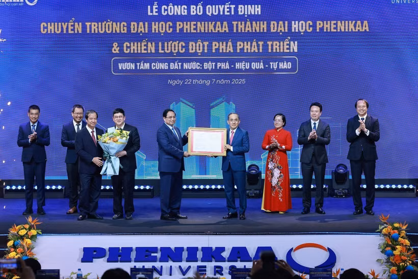 El primer ministro Pham Minh Chinh (quinto de derecha) entrega la decisión del Gobierno a dirigente de la Universidad Phenikaa (Foto: VNA)