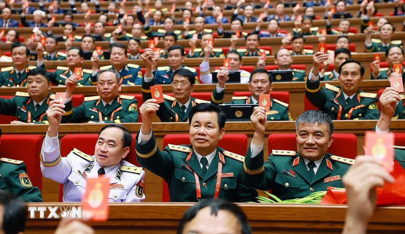 Los delegados votan para aprobar la Resolución del XIV Congreso Nacional del Partido. (Foto: VNA)
