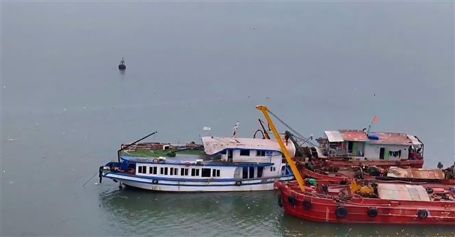 El barco turístico Vinh Xanh 58 es remolcado a tierra la mañana del 20 de julio. (Foto: VNA)