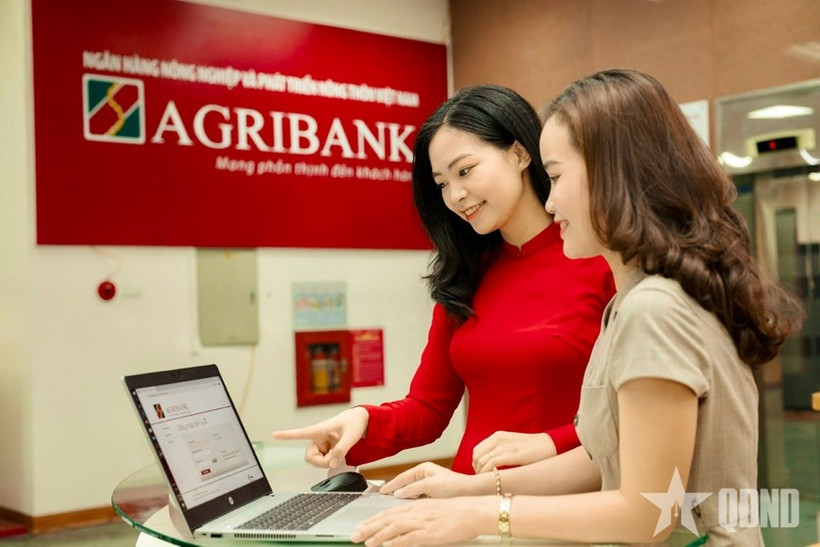 Empleados del Banco de Desarrollo Agrícola y Rural de Vietnam (Agribank) orientan a sus clientes sobre cómo realizar transacciones seguras en canales digitales. Foto: qdnd.vn