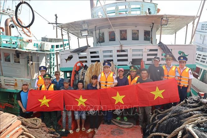 El Comando de la Región 3 de la Guardia Costera organizó un programa para difundir las leyes sobre la lucha contra la pesca IUUy entregó banderas nacionales a los pescadores. Foto: VNA