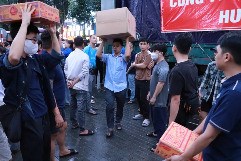 Voluntarios se afanan cargando y transportando mercancías y artículos de primera necesidad. (Foto: VNA)
