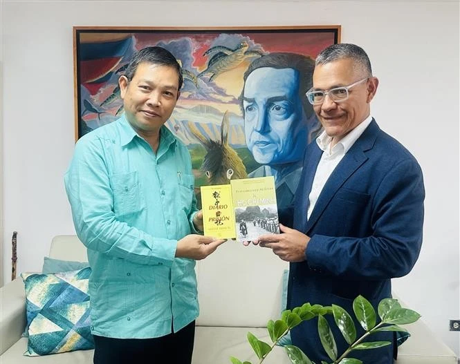 El embajador de Vietnam en Venezuela, Vu Trung My, entrega al ministro venezolano de Cultura, Ernesto Villegas, de obras representativas del Presidente Ho Chi Minh. (Foto: VNA)