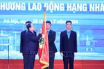 El presidente de la Asamblea Nacional, Tran Thanh Man, coloca la Orden del Trabajo de primera clase en la bandera tradicional de la Confederación General del Trabajo de Vietnam. (Fuente: VNA)