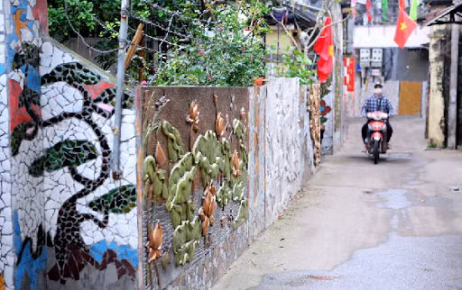 Pared hecha de materiales reciclables embellece aldea vietnamita ảnh 1