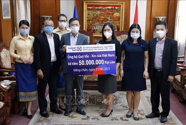 Vietnamitas en Laos contribuyen al fondo nacional de vacunas contra el COVID-19 ảnh 1