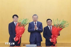 El secretario general del Partido Comunista de Vietnam, To Lam, entrega flores al miembro del Buró Político y presidente. Luong Cuong. y el miembro del Buró Político y permanente del Secretariado del Comité Central del Partido. (Foto: VNA)